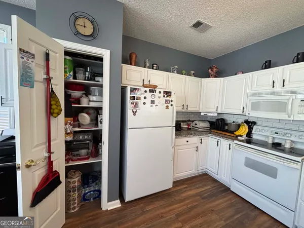 a kitchen with a table chairs stove and kitchen view