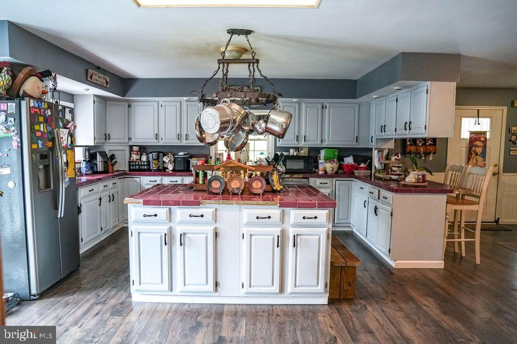 76 Northville Road Bridgeton, NJ 08302 - Photo 27 of 63 a kitchen with kitchen island granite countertop a sink cabinets and wooden floor