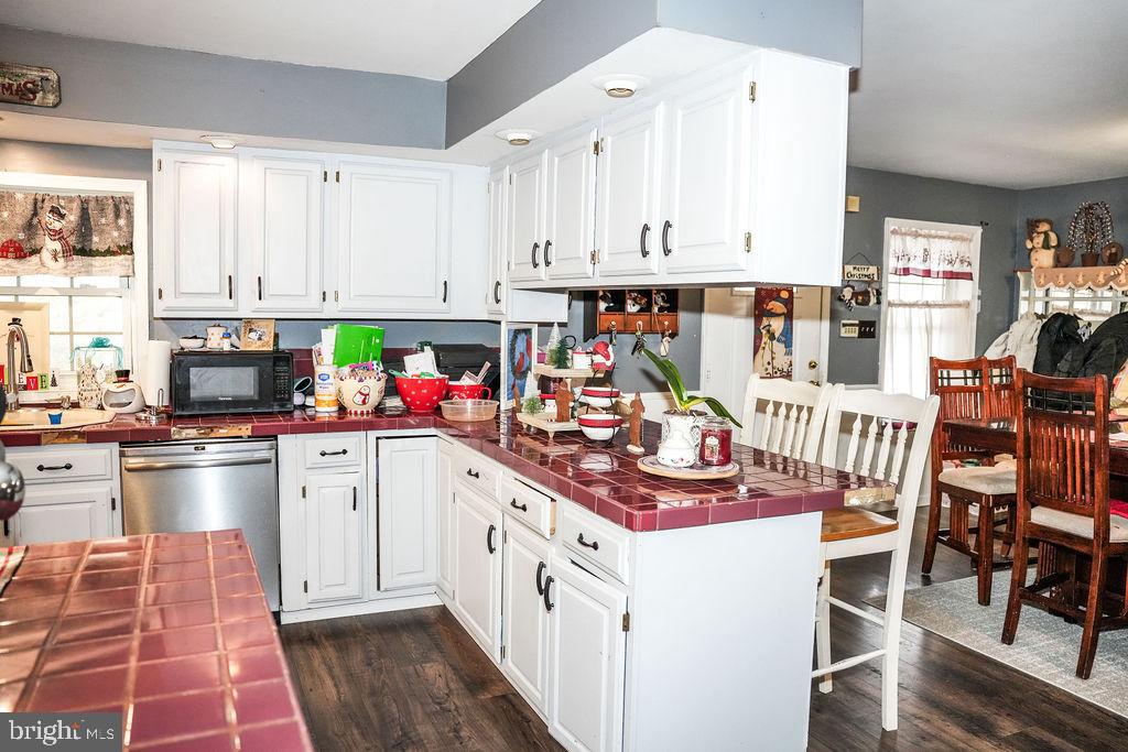 76 Northville Road Bridgeton, NJ 08302 - Photo 31 of 63 a kitchen with stainless steel appliances a stove top oven a sink dishwasher and white cabinets with wooden floor