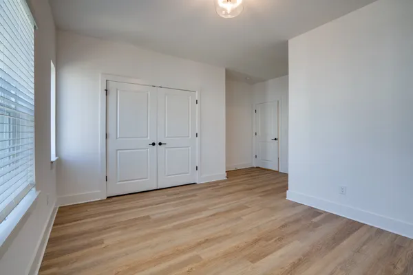 a view of an empty room with wooden floor