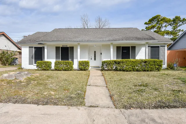 a front view of a house with a yard and potted plants