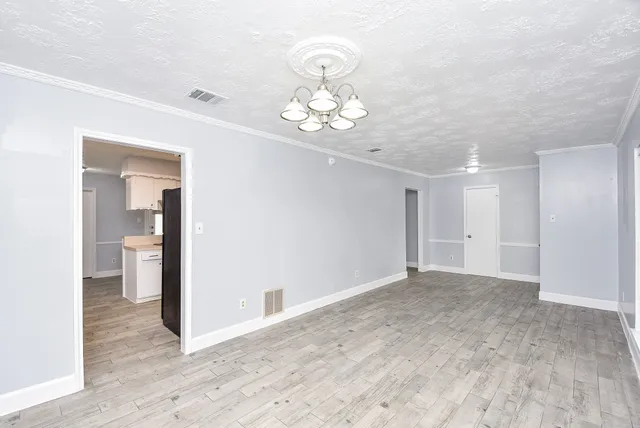 a view of an empty room with wooden floor
