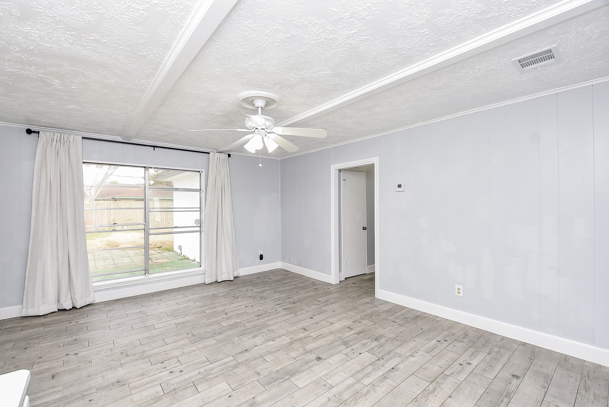 11623 Kirkhollow Drive Houston, TX 77089 - Photo 16 of 32 an empty room with wooden floor chandelier fan and windows