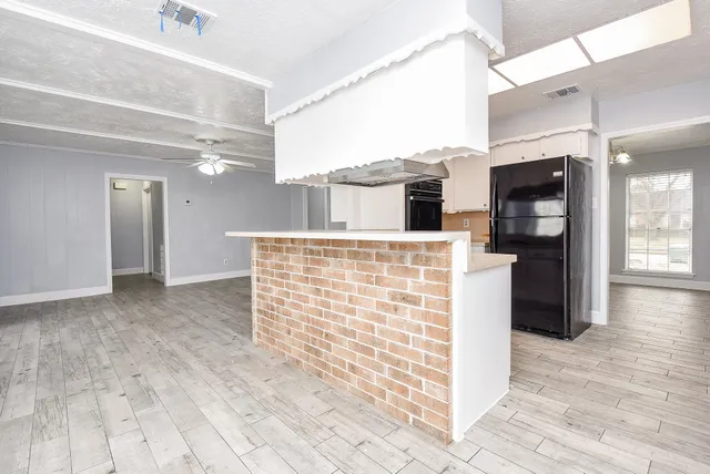 a view of open kitchen with kitchen island refrigerator sink and wooden floor