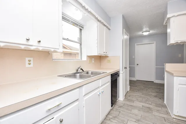 a kitchen with a sink stove and cabinets