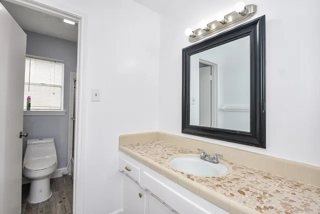 a bathroom with a granite countertop sink and a mirror