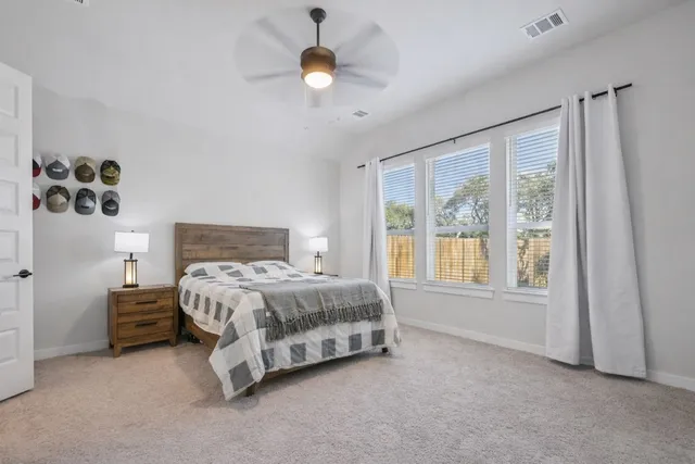 a spacious bedroom with a large bed and a chandelier