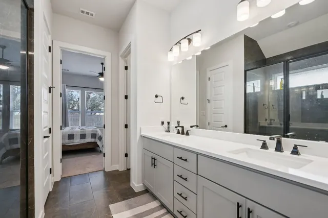a en suite spacious bathroom with double sink and mirrors