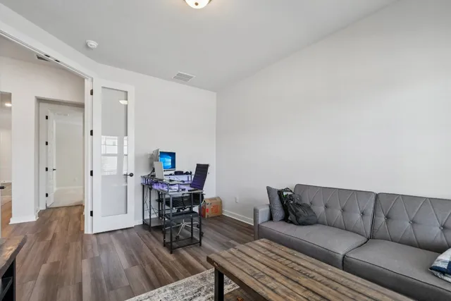 a living room with furniture and a wooden floor