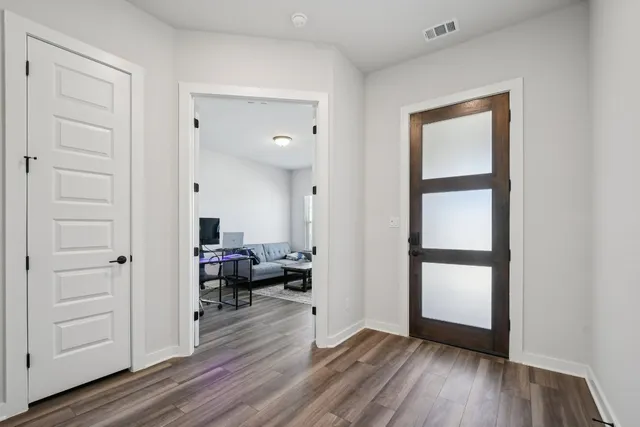 a view of a room with wooden floor cabinet and windows