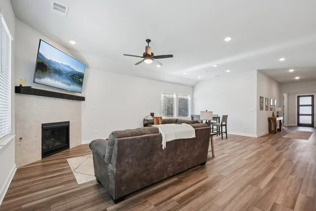 a living room with furniture a fireplace and wooden floor