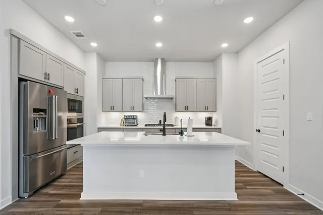 a kitchen with kitchen island a sink stainless steel appliances and refrigerator