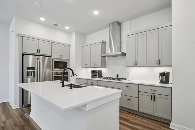 a kitchen with stainless steel appliances a sink stove refrigerator and cabinets