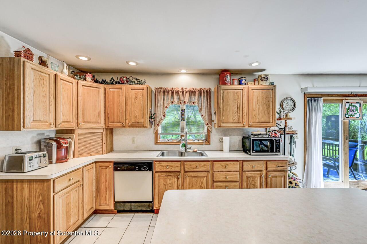 314 Reynolds Road Factoryville, PA 18419 - Photo 16 of 58 a kitchen with stainless steel appliances kitchen island wooden cabinets a sink and a large window