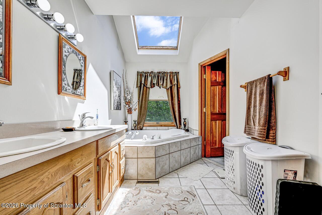 314 Reynolds Road Factoryville, PA 18419 - Photo 30 of 58 a spacious bathroom with a double vanity sink a mirror and a bathtub