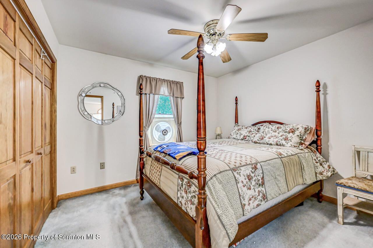 314 Reynolds Road Factoryville, PA 18419 - Photo 43 of 58 a bedroom with a bed chandelier and a window