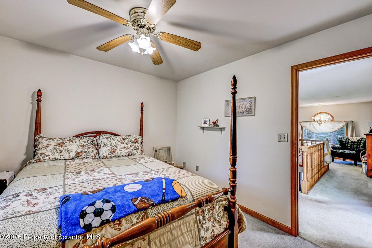 314 Reynolds Road Factoryville, PA 18419 - Photo 44 of 58 a bedroom with a bed and a chandelier