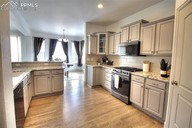 a kitchen with stainless steel appliances granite countertop a stove top oven a sink dishwasher and a refrigerator