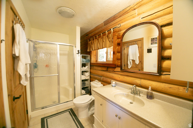 348 North Jakes Pl Road Loa, UT 84747 - Photo 9 of 26 Full bathroom featuring vanity, a shower stall, log walls, and light tile patterned floors