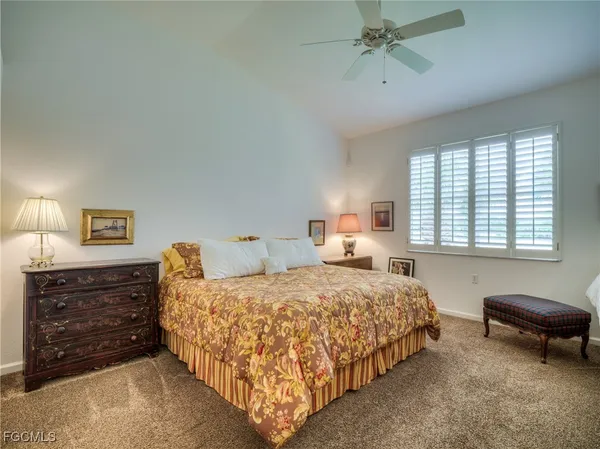 a bedroom with a bed a couch and a dresser next to a window