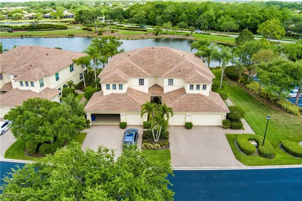 an aerial view of a house with a garden and lake view
