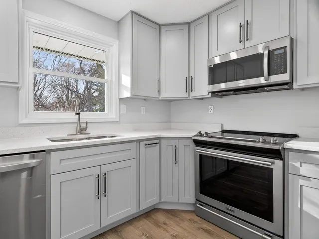 a kitchen with stainless steel appliances white cabinets and a stove top oven