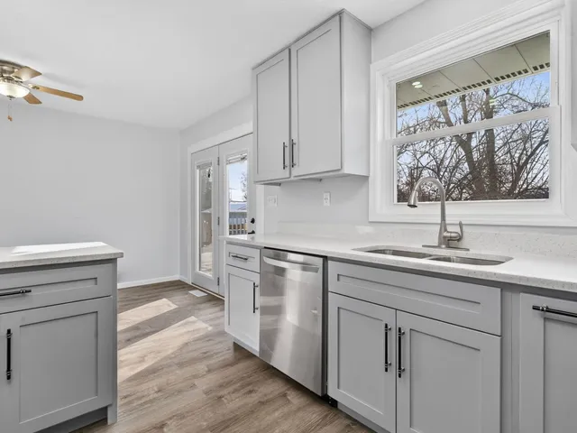 a kitchen with white cabinets and sink