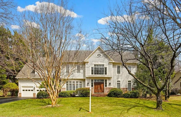 a aerial view of a house with yard plants and large tree