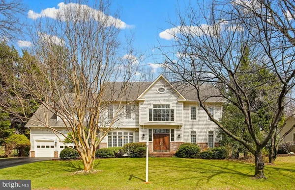 a view of a white house with a big yard and large tree