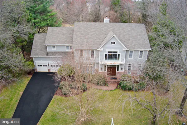 a aerial view of a house with yard plants and large tree