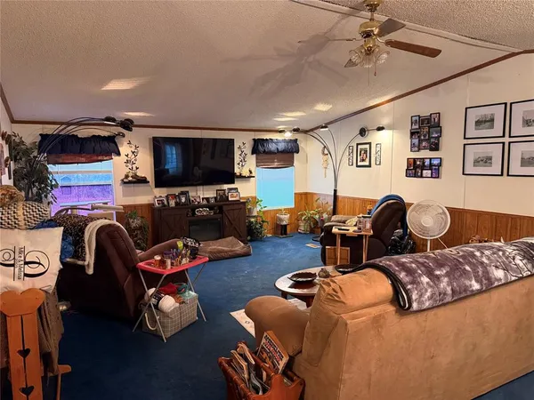 a living room with furniture a flat screen tv and gym equipment