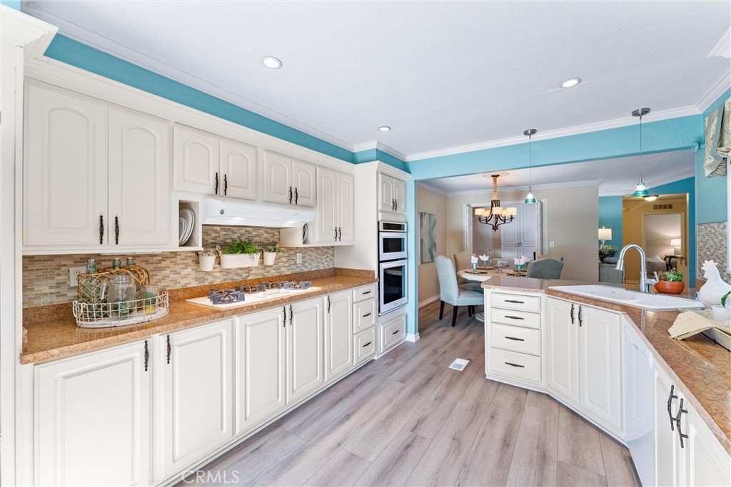 2529 Shadow Santa Ana, CA 92705 - Photo 17 of 45 a kitchen with stainless steel appliances granite countertop a stove a sink and white cabinets with wooden floor