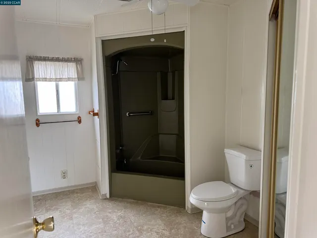a bathroom with a toilet and a shower