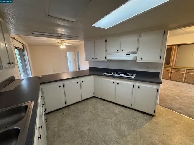 a kitchen with granite countertop white cabinets and white appliances