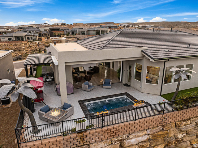 3022 West Sesia Way St. George, UT 84770 - Photo 16 of 52 Back of property with stucco siding, a patio, an outdoor living space with a fire pit, and a fenced backyard