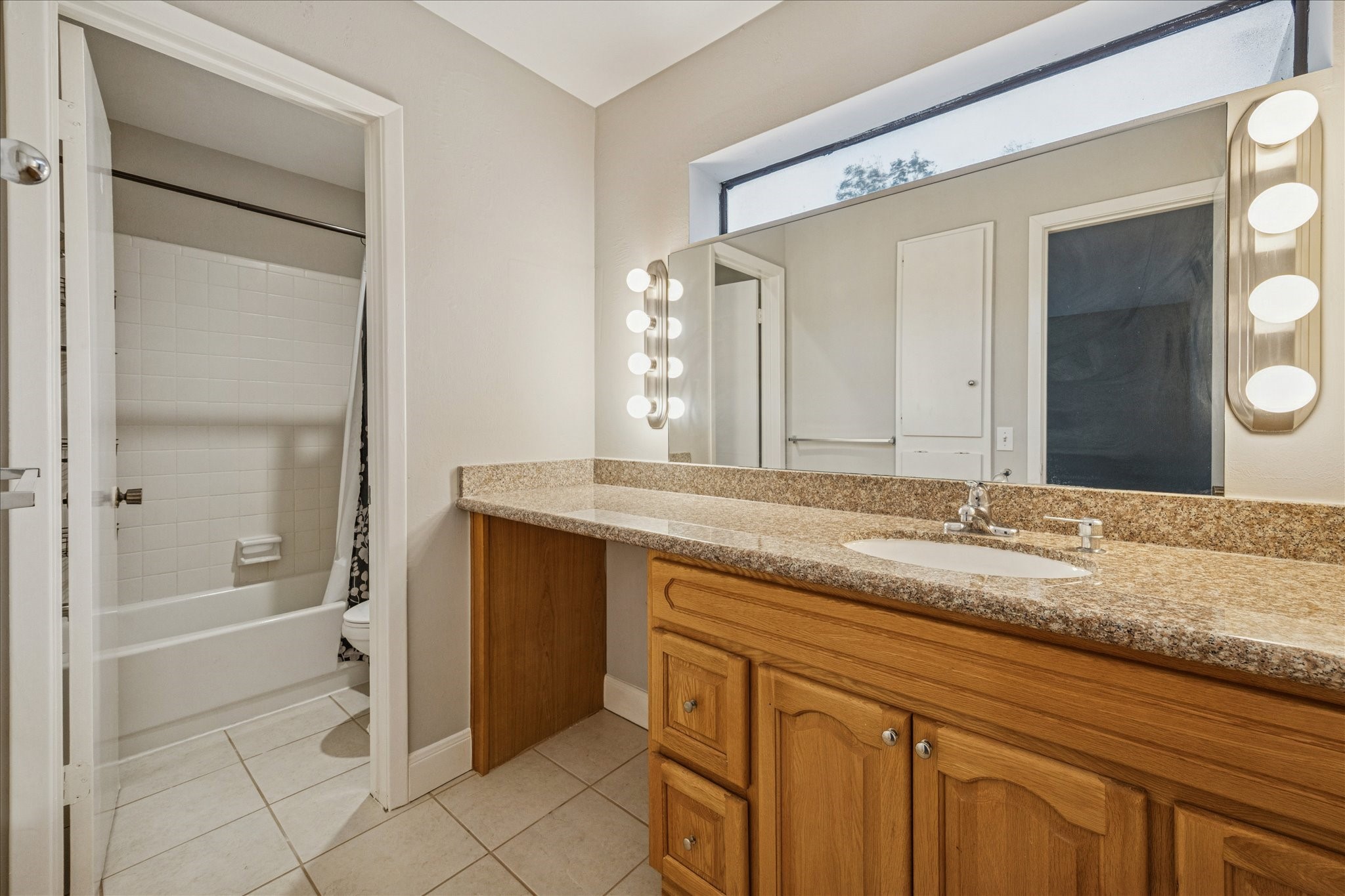 1615 Prairie Mark Lane Houston, TX 77077 - Photo 16 of 25 This is the ensuite bathroom to the secondary bedroom. Natural lighting through the window above the sink, nice vanity area, and you can close the door to the bath tub/shower/toilet.