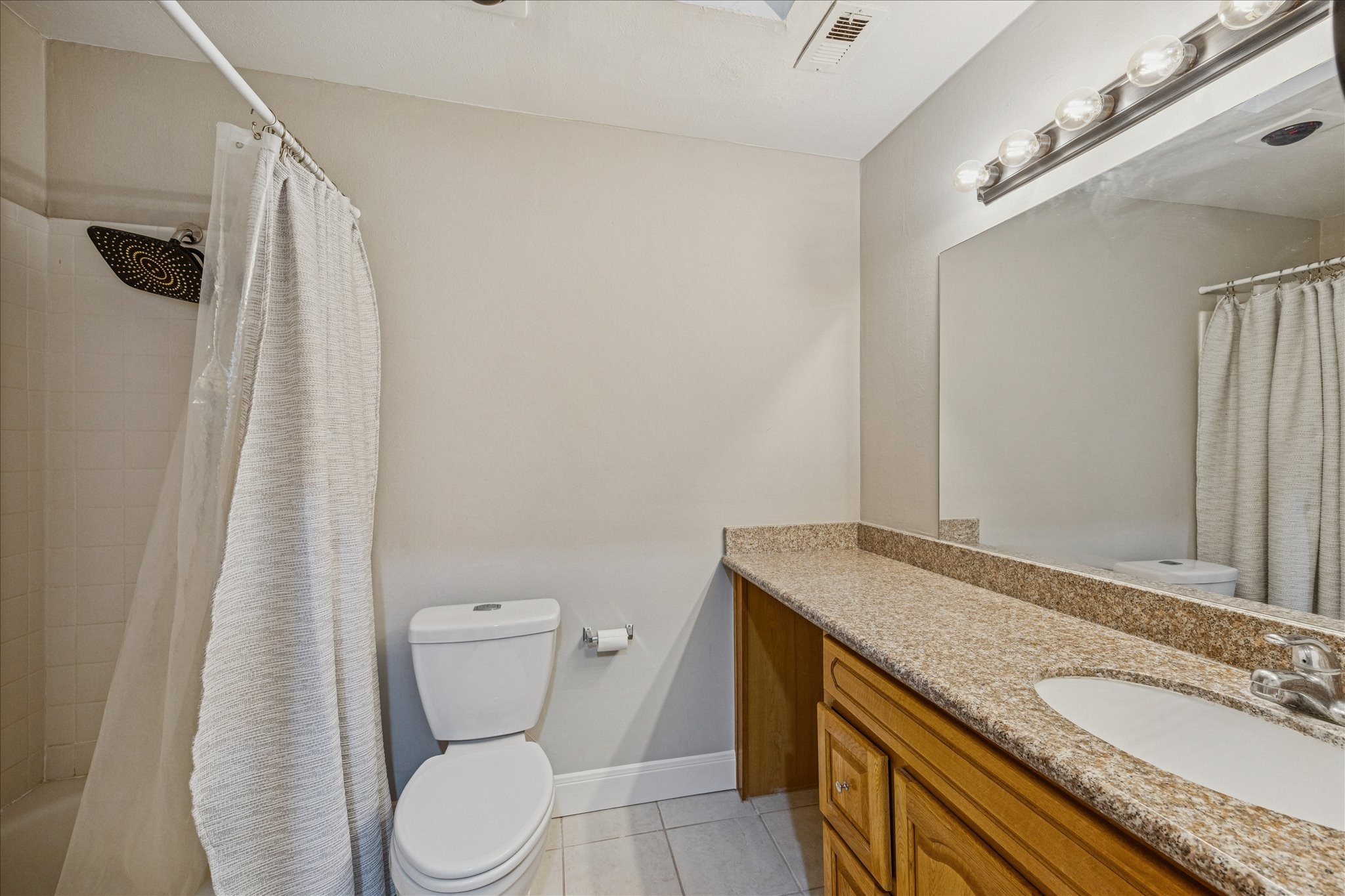 1615 Prairie Mark Lane Houston, TX 77077 - Photo 18 of 25 Between the primary bedroom and bathroom are 2 closets, one on each side. And here is the bathroom with a vanity area, it has a sky light above, and tub with shower. BTW ... the water, sewer and garbage are included in the monthly HOA fee.
