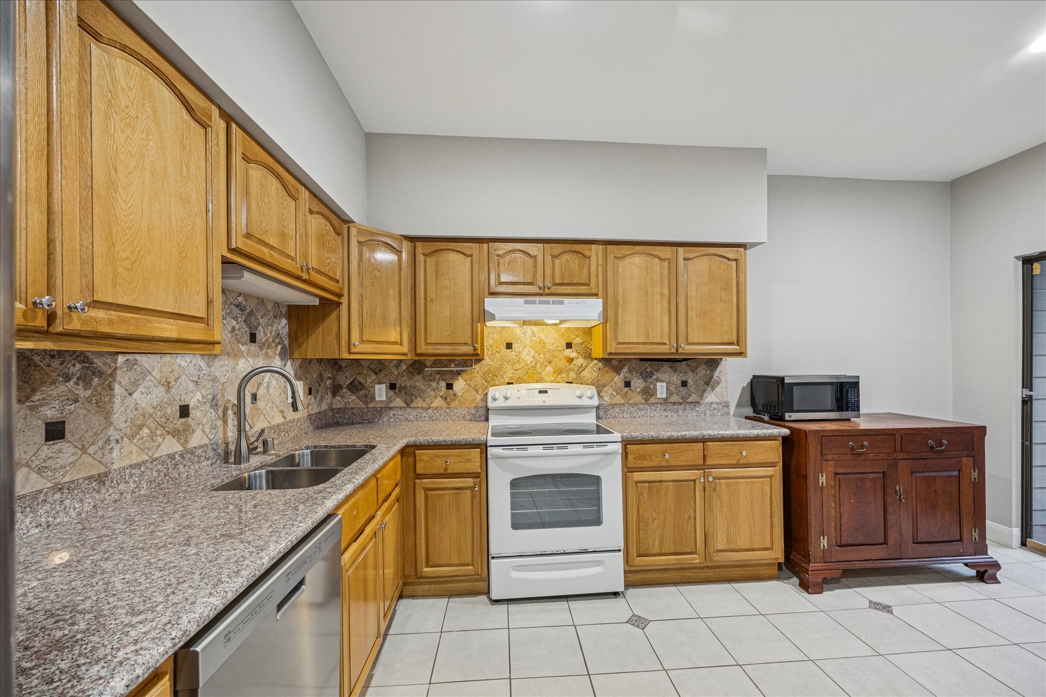 1615 Prairie Mark Lane Houston, TX 77077 - Photo 9 of 25 Now we are going into the kitchen. The microwave is included, as is the piece of furniture it sits on. You could move that piece of furniture and put a little dining table there.