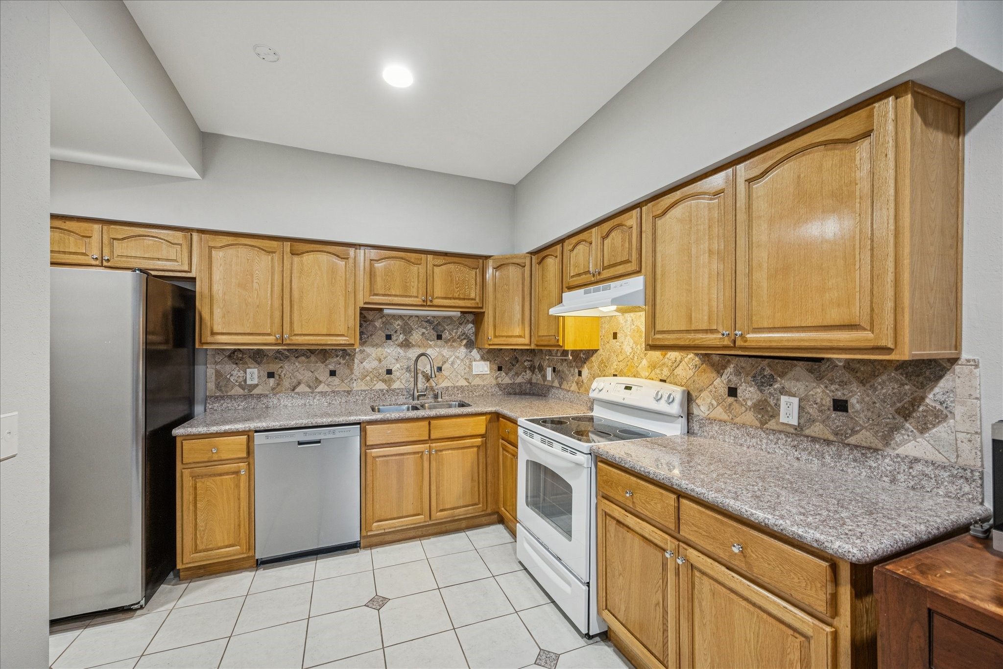 1615 Prairie Mark Lane Houston, TX 77077 - Photo 10 of 25 This is a view of the kitchen from the sliding glass door leading out to the deck. Tile flooring, Silestone countertops, undermount sink, tons of storage and refrigerator stays! The walk-in pantry is across from the refrigerator.
