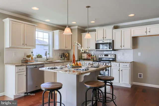 a kitchen with stainless steel appliances kitchen island granite countertop a stove a sink a refrigerator and chairs