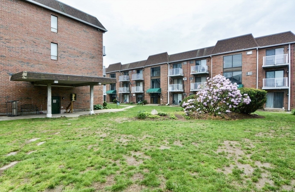 1186 Worcester Road, Unit 720 Framingham, MA 01702 - Photo 14 of 15 front view of a brick house with a yard