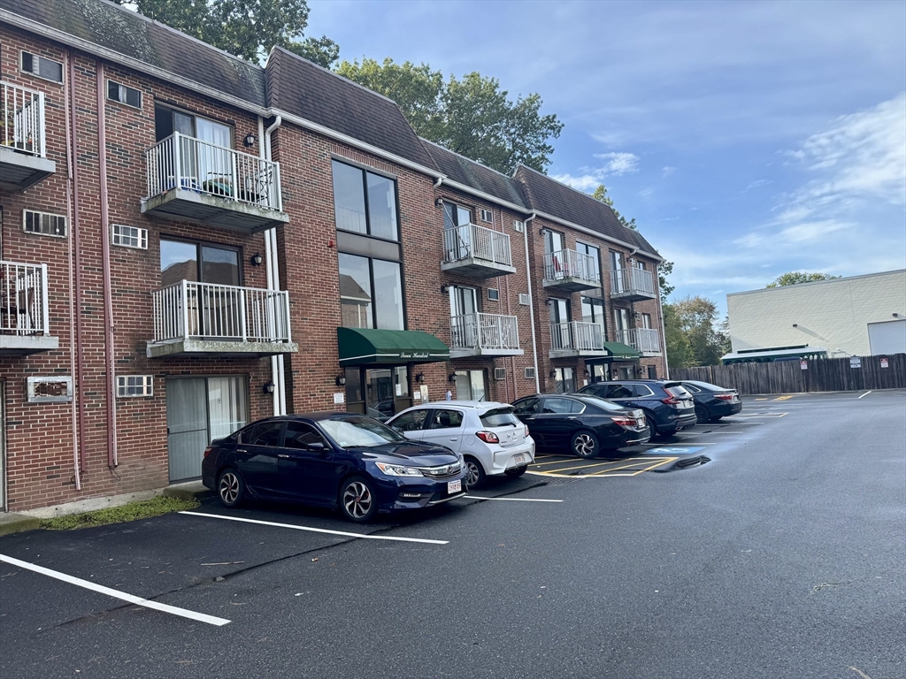 1186 Worcester Road, Unit 720 Framingham, MA 01702 - Photo 15 of 15 a car parked in front of a brick house