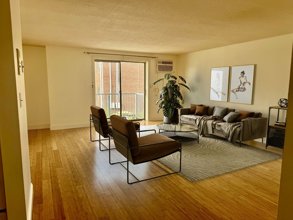 1186 Worcester Road, Unit 720 Framingham, MA 01702 - Photo 2 of 15 a living room with furniture and a wooden floor