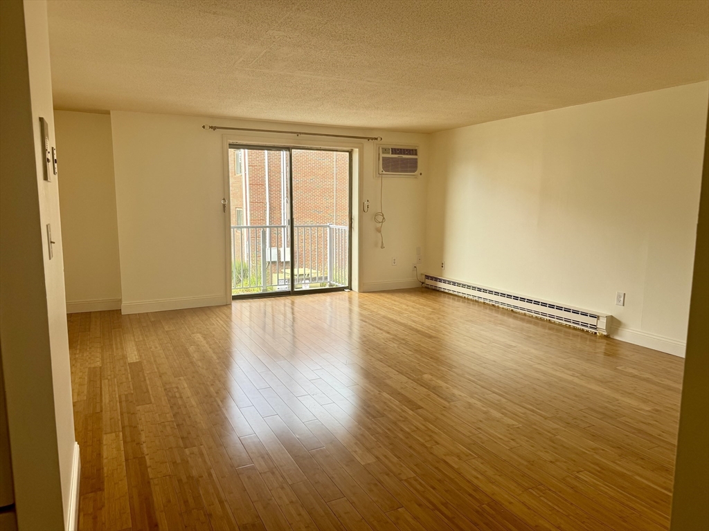 1186 Worcester Road, Unit 720 Framingham, MA 01702 - Photo 3 of 15 a view of an empty room with wooden floor and a window