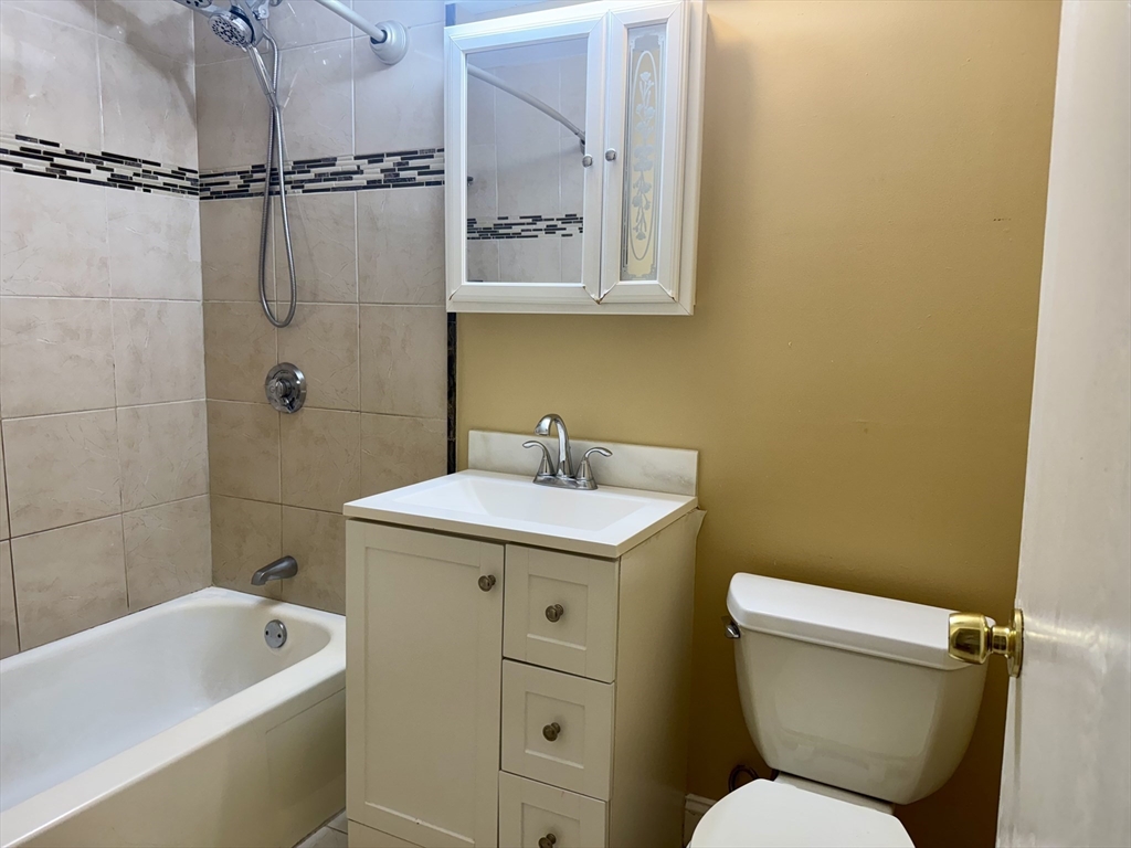 1186 Worcester Road, Unit 720 Framingham, MA 01702 - Photo 9 of 15 a bathroom with a sink a mirror a toilet and bathtub