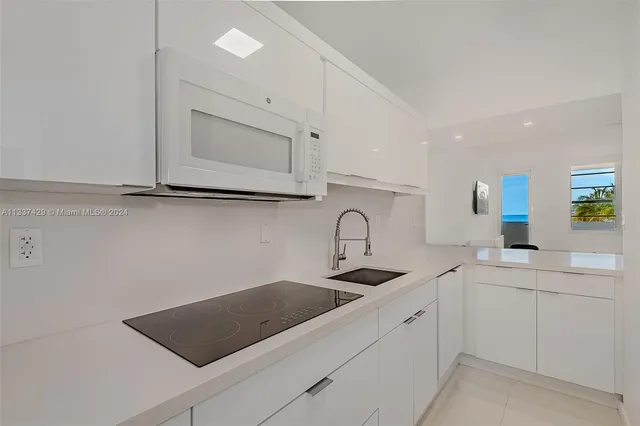 a kitchen with white cabinets a sink and a stove