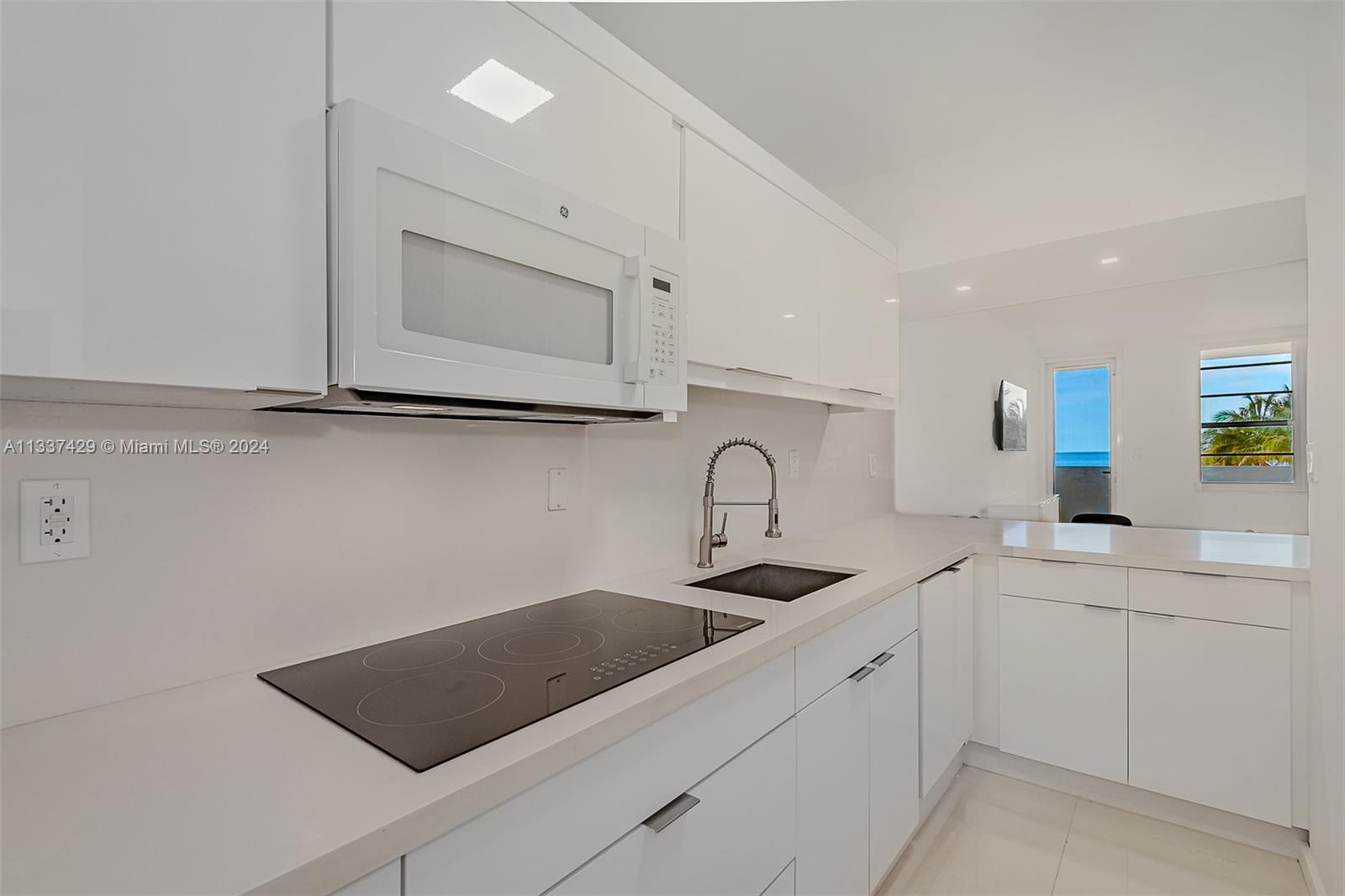 100 Lincoln Road, Unit 519 Miami Beach, FL 33139 - Photo 11 of 15 a kitchen with white cabinets a sink and a stove