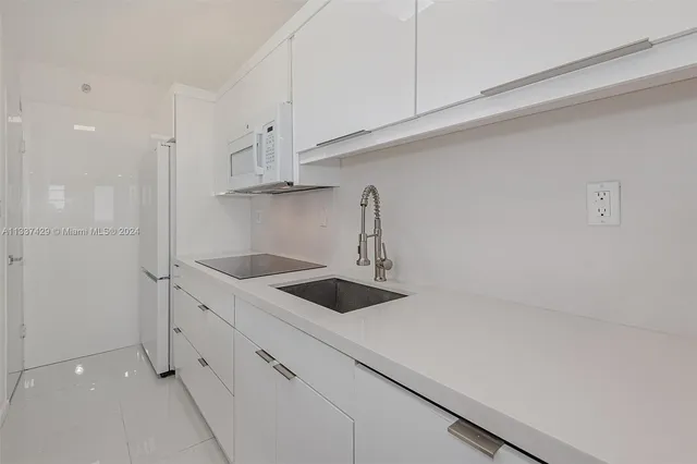 a kitchen with white cabinets and a sink