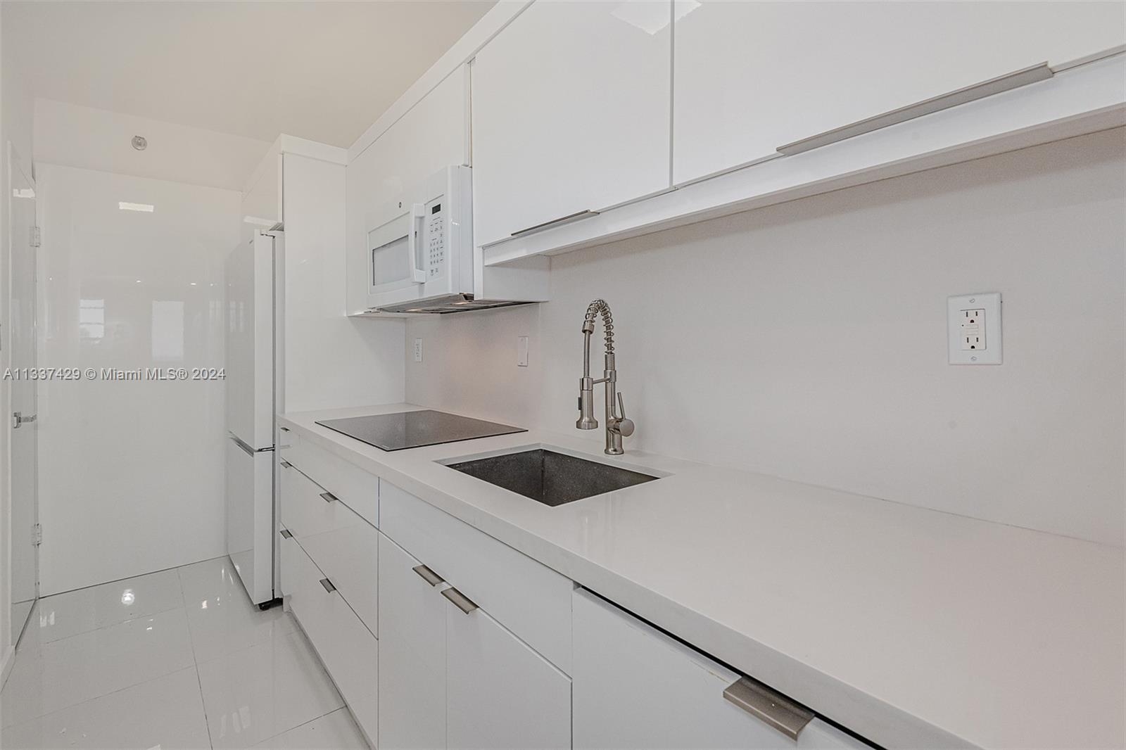 100 Lincoln Road, Unit 519 Miami Beach, FL 33139 - Photo 10 of 15 a kitchen with white cabinets and a sink