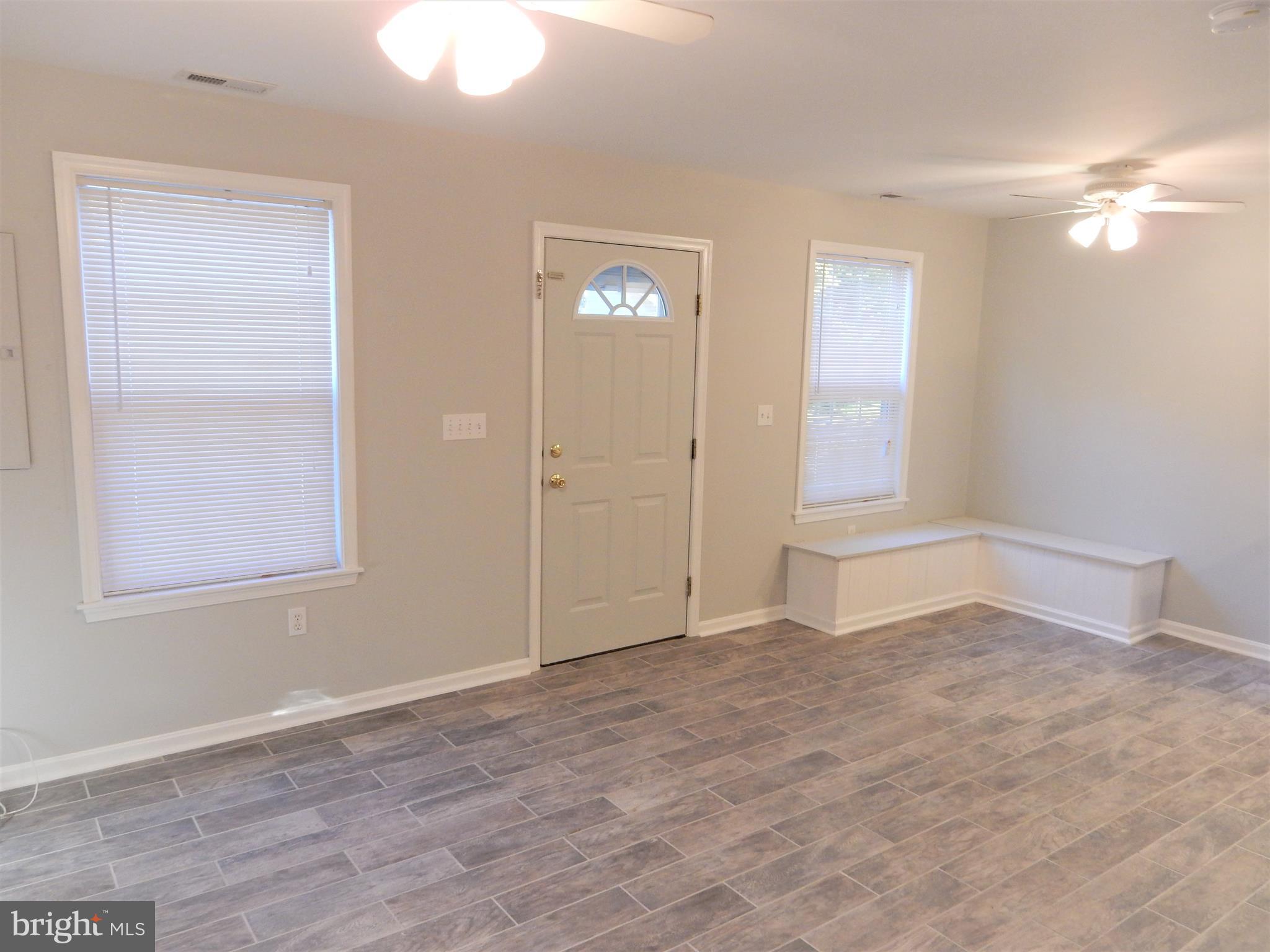 306 Oakwood Road Edgewater, MD 21037 - Photo 5 of 36 a view of an empty room with window and wooden floor
